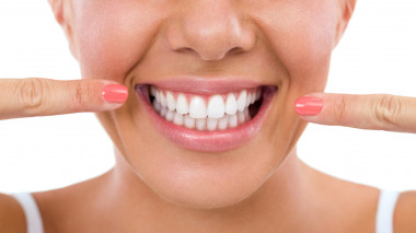 Frau präsentiert ihren weißen Zähne